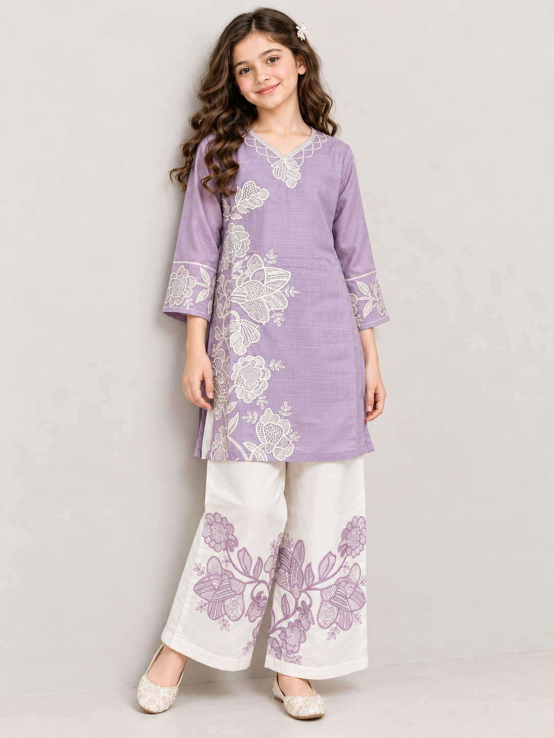 Model wearing the purple cotton embroidery kurti set, standing by a wall