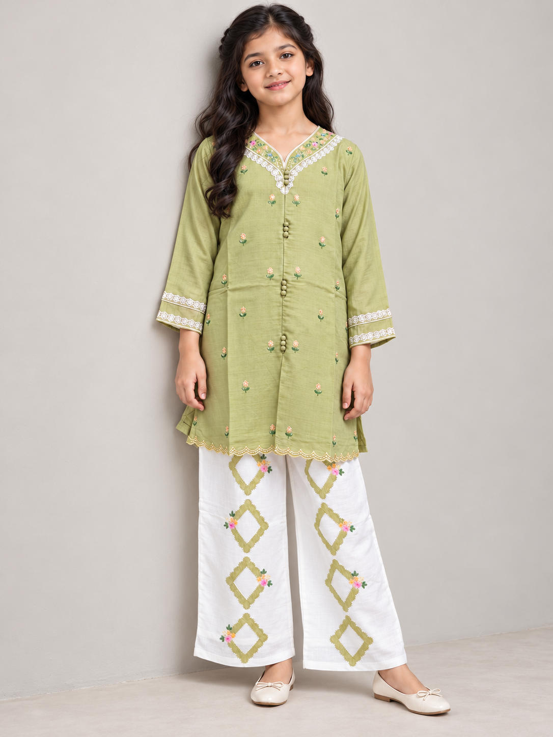 Model wearing the green cotton embroidery kurti set, standing by a wall