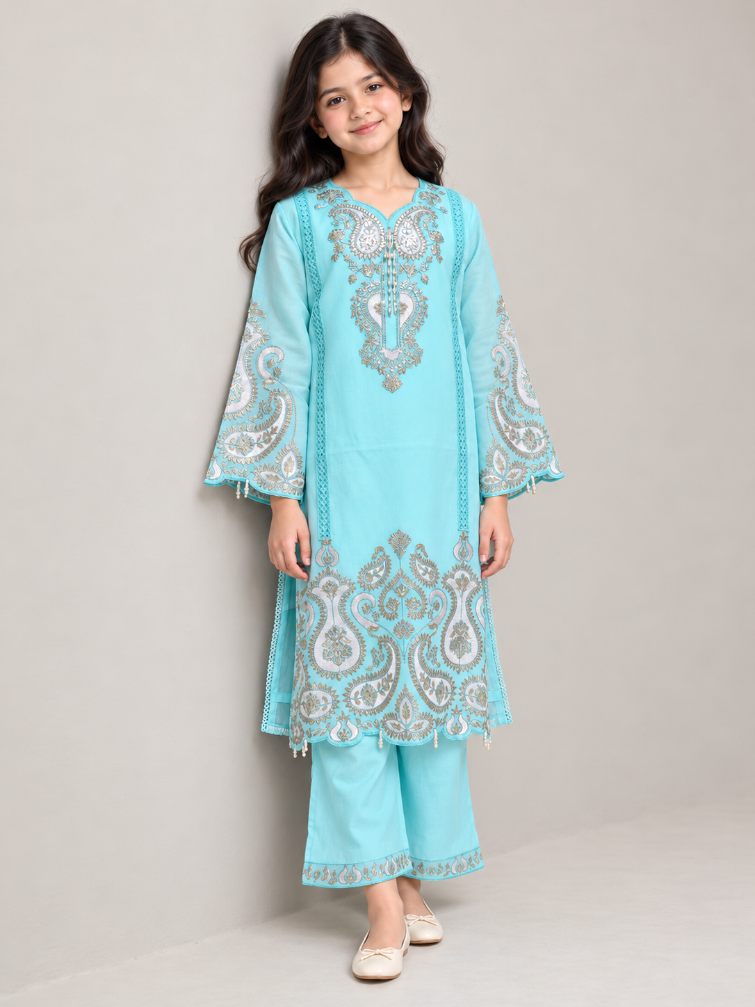 Model wearing the blue cotton embroidery kurti set, standing by a wall